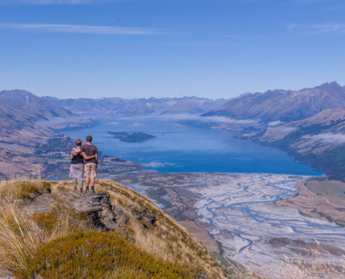 Couple standing with arms around each other on top of Mt Alfred Glenorchy