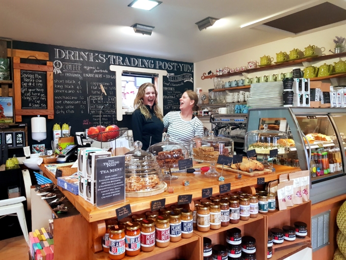 2 ladies laughing behind the counter in the The Trading Post cafe Glenorchy