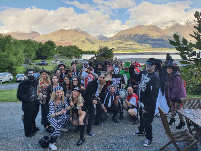 Group of people in halloween costumes posing in front of mountain view from Kinloch