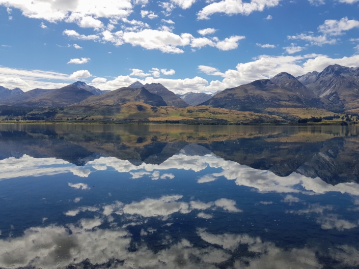 Mountains of Glenorchy reflected in Lake Wakatipu on sunny day