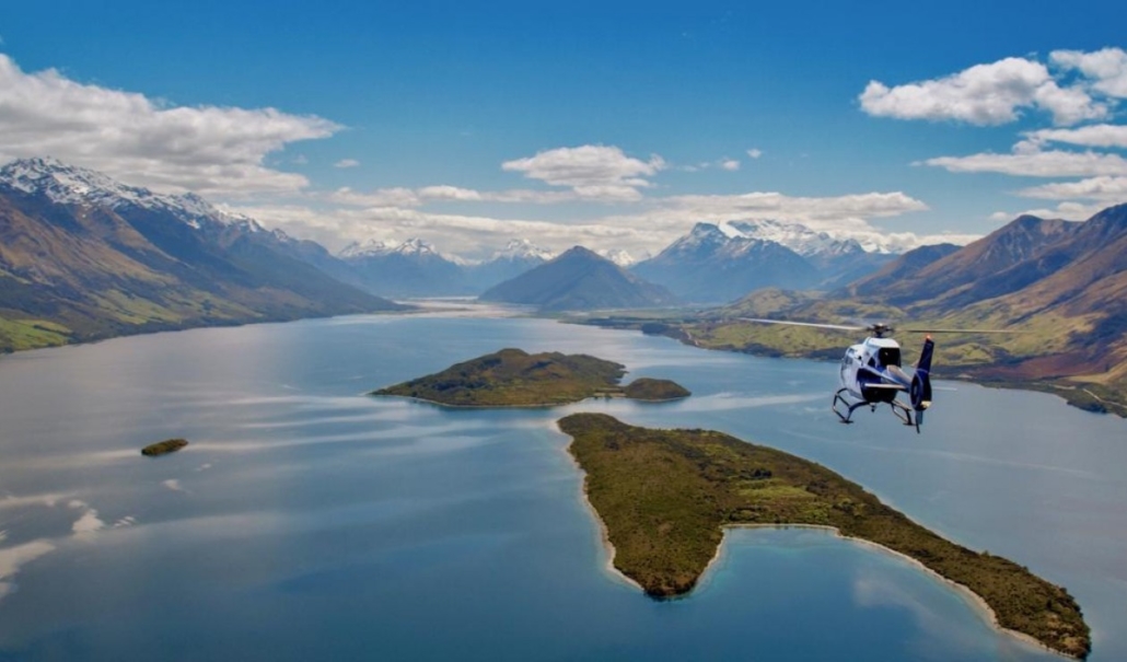 Helicopter flying towards Glenorchy over 2 islands in Lake Wakatipu