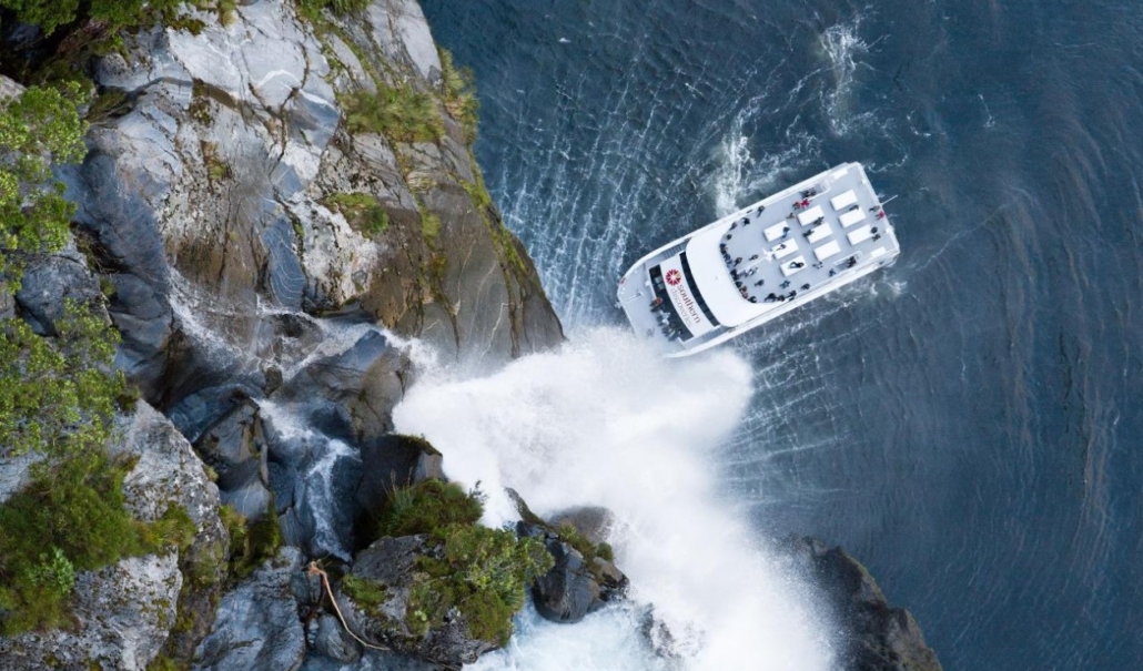 Aerial shot of Milford Cruise boat at the bottom of a waterfall