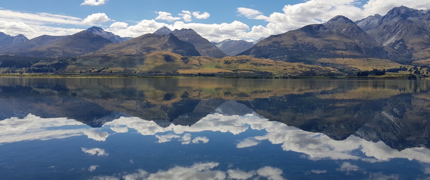 Mountains of Glenorchy reflected in Lake Wakatipu on sunny day