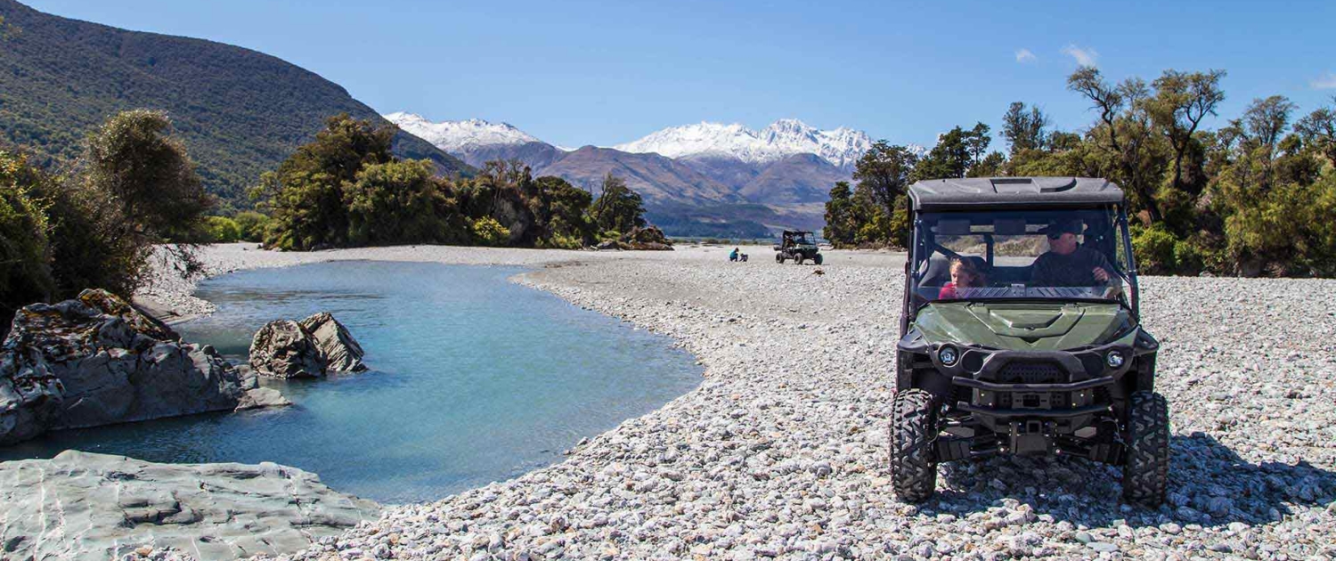 Electric 4WD next to river with mountains